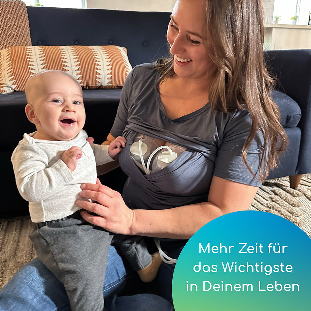 Frau hält ihren Sohn auf dem Schoß während sie freihändig abpumpt