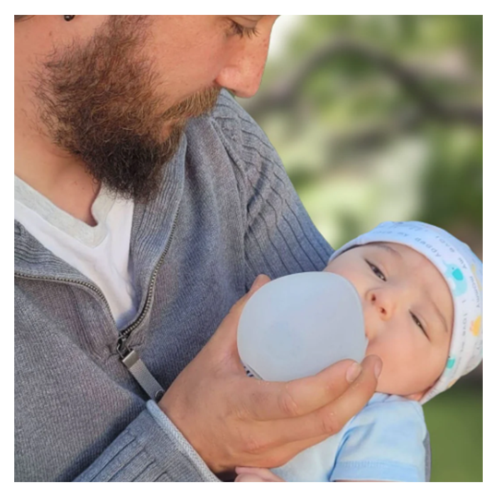 ein Vater füttert sein Baby mit ardo kindestCup milchauffangschale und fütterungsbecher in einem